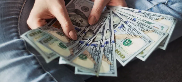 A girl holding money and thinking about tips for moving in together in NYC;